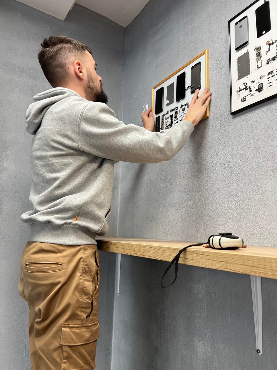 Michal vešia rámy s rozobratými iPhonmi